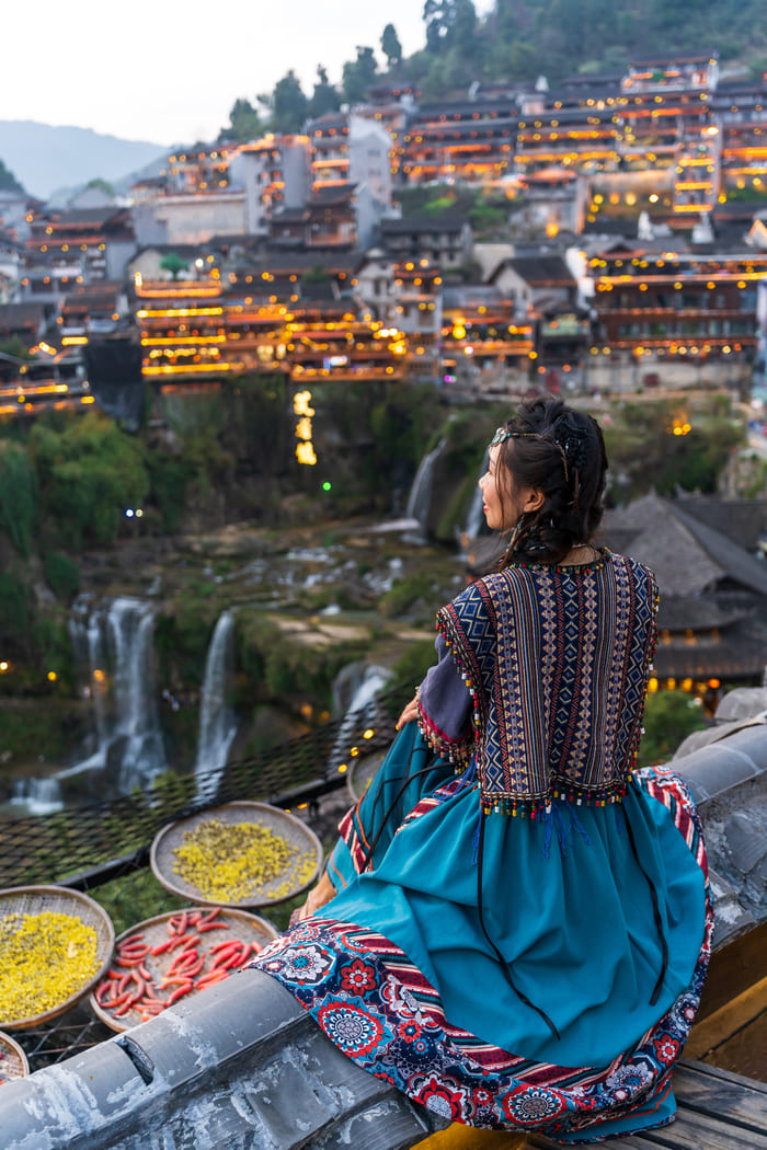 Chicas sentada obserbando la ciudad de lijiang